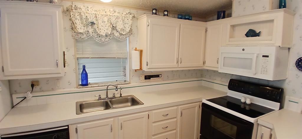 278 Pine Loop Frostproof, FL 33843 - Photo 15 of 40 a kitchen with white cabinets and a sink