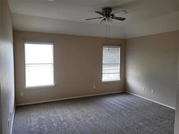 an empty room with a window and a ceiling fan