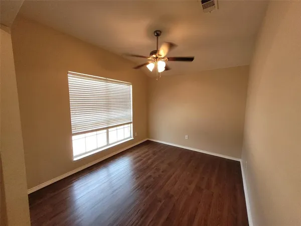 a view of wooden floor and a chandelier fan in a room