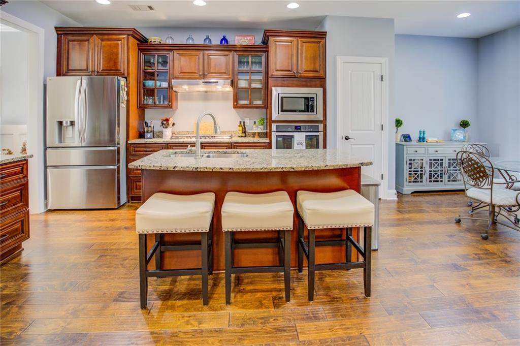 1021 Arbor Court Madison, GA 30650 - Photo 17 of 64 a room with stainless steel appliances kitchen island granite countertop furniture and a refrigerator