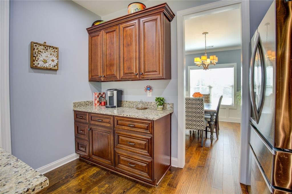 1021 Arbor Court Madison, GA 30650 - Photo 21 of 64 a kitchen with stainless steel appliances granite countertop a refrigerator a stove a sink and a dining table with garden view