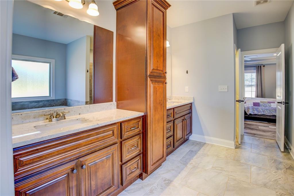 1021 Arbor Court Madison, GA 30650 - Photo 34 of 64 a en suite bathroom with a double vanity sink and a mirror
