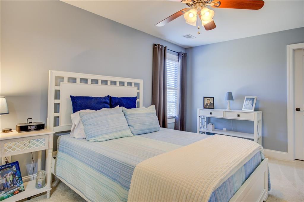 1021 Arbor Court Madison, GA 30650 - Photo 52 of 64 a bedroom with a bed and a chandelier