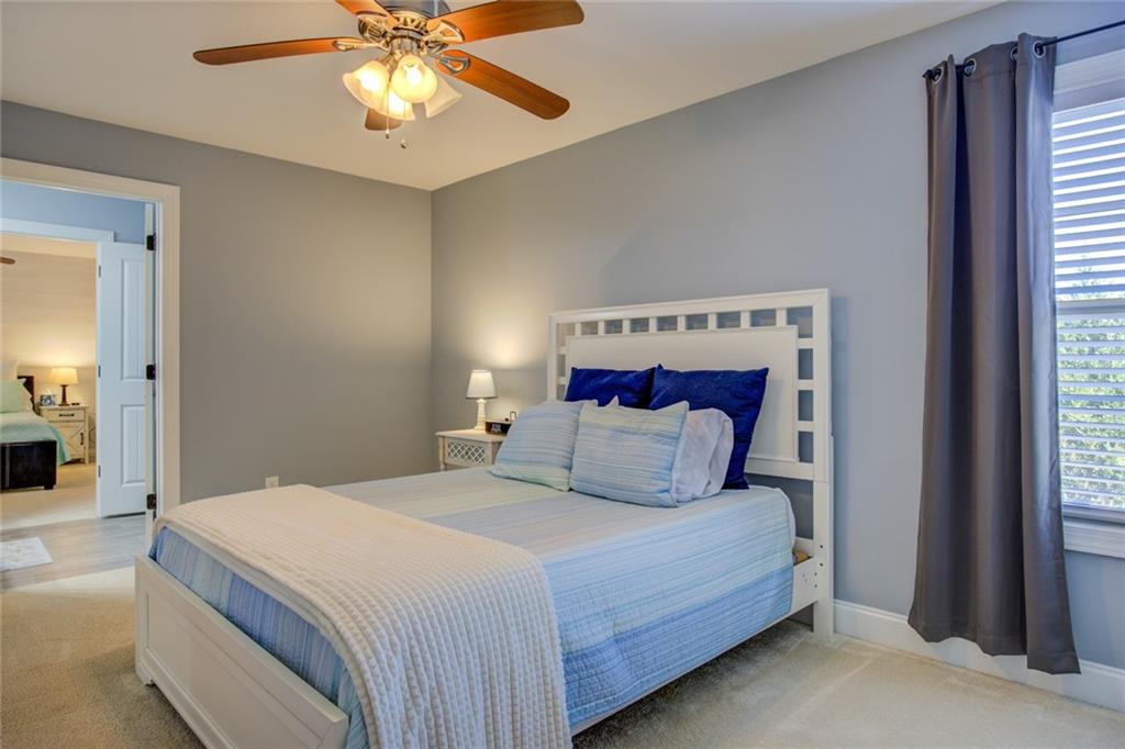 1021 Arbor Court Madison, GA 30650 - Photo 53 of 64 a bedroom with a bed and a chandelier