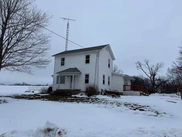 a front view of a house with a yard covered in snow