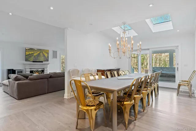 a view of a dining room with furniture a chandelier and wooden floor