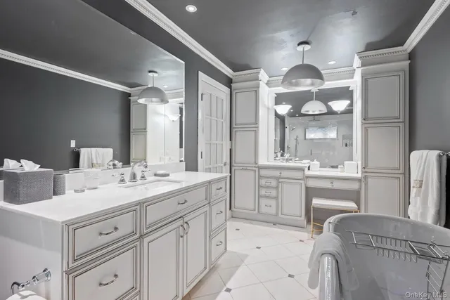 a large white kitchen with a white cabinets and chandelier