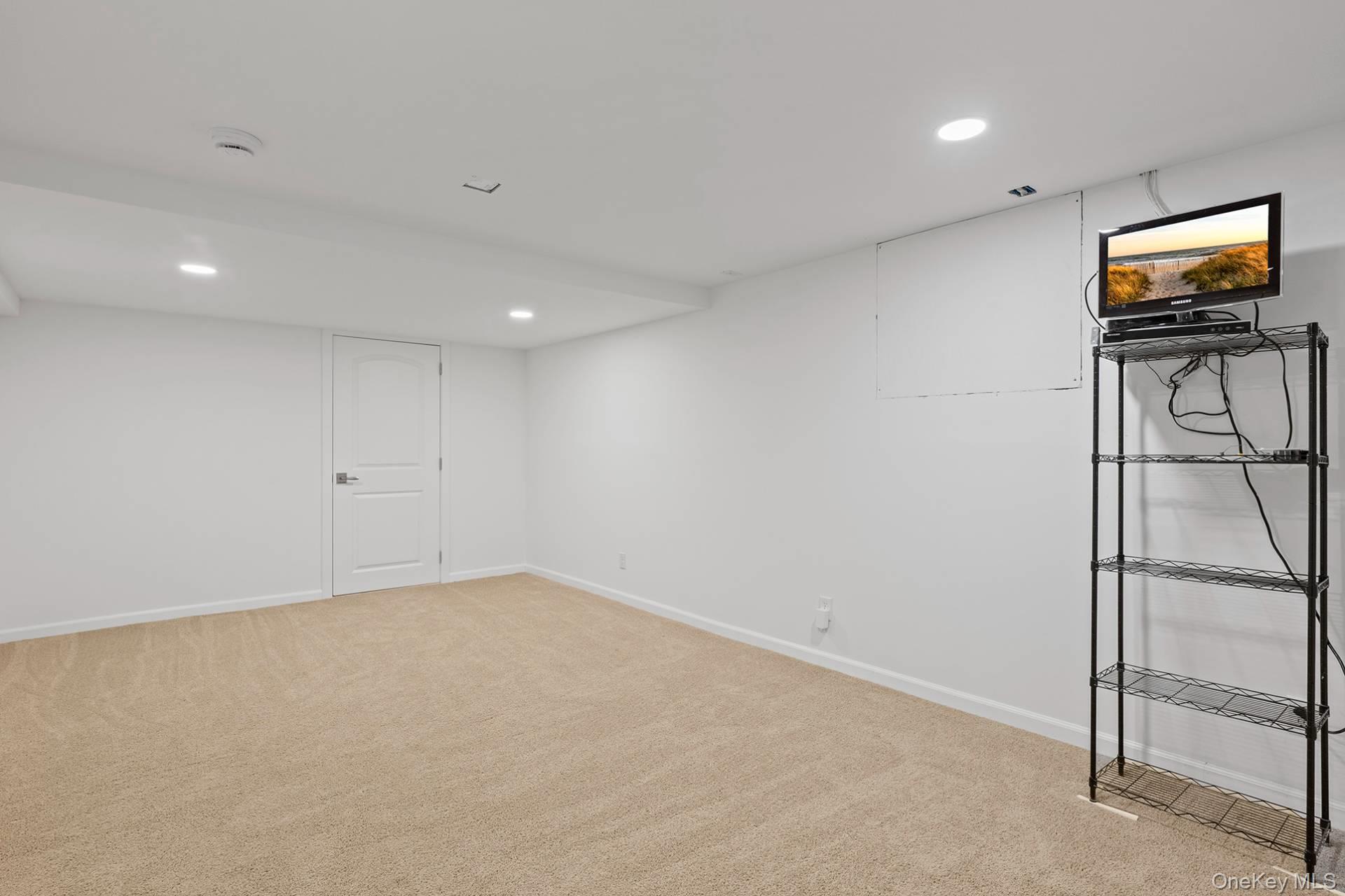 1824 Majors Path Southampton, NY 11968 - Photo 28 of 28 Finished below grade area with recessed lighting and light colored carpet