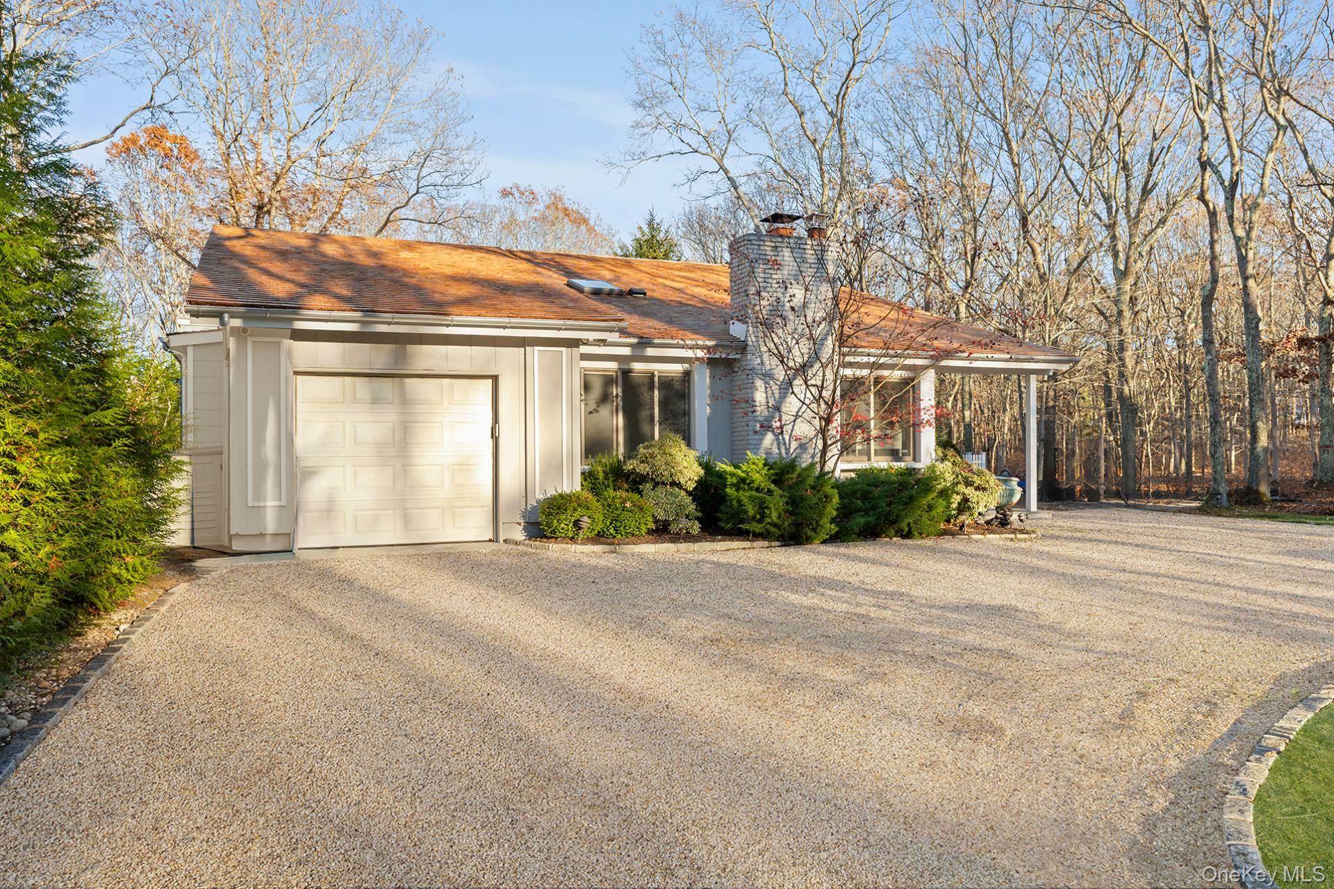 1824 Majors Path Southampton, NY 11968 - Photo 5 of 28 front view of a house with a bench and trees