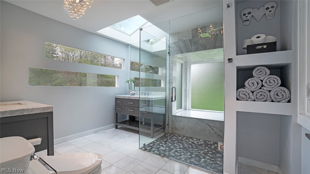 4089 Brainard Road Chagrin Falls, OH 44022 - Photo 13 of 25 Beautiful master bath with double marble topped vanities, zero threshold shower with integrated seating, built-in shelving and custom windows.
