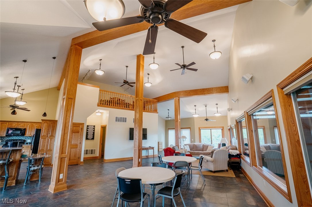 36328 Eagleton Road Lisbon, OH 44432 - Photo 32 of 49 Dining room with a ceiling fan, high vaulted ceiling, dark stone finish flooring, and baseboards