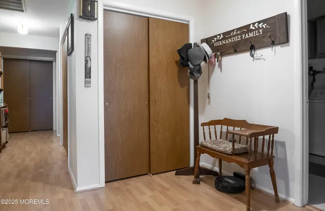 a view of a hallway with entryway wooden floor and front door