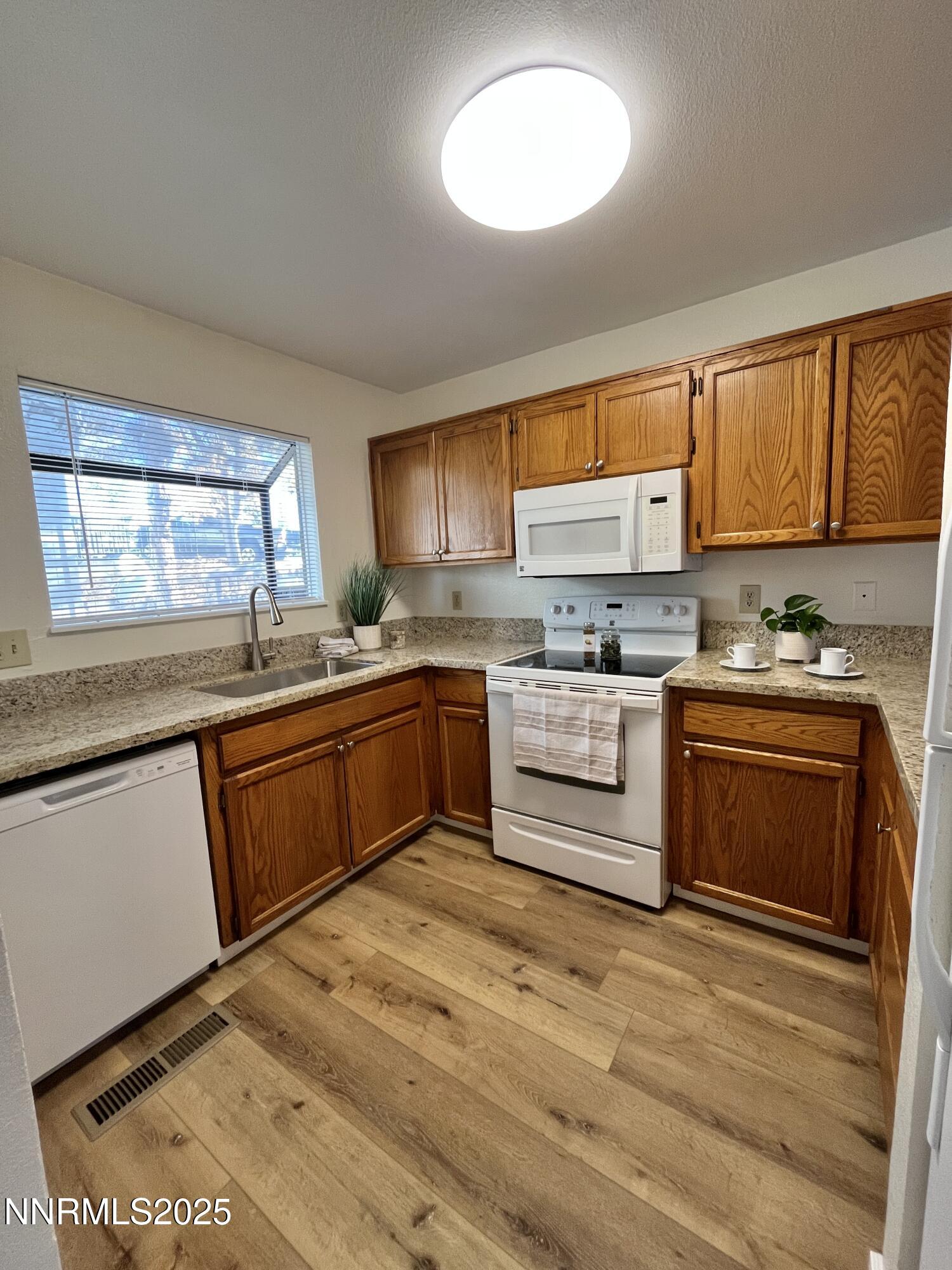 4985 West 7th Street, Unit 16 Reno, NV 89503 - Photo 1 of 10 a kitchen with a stove a sink and a microwave