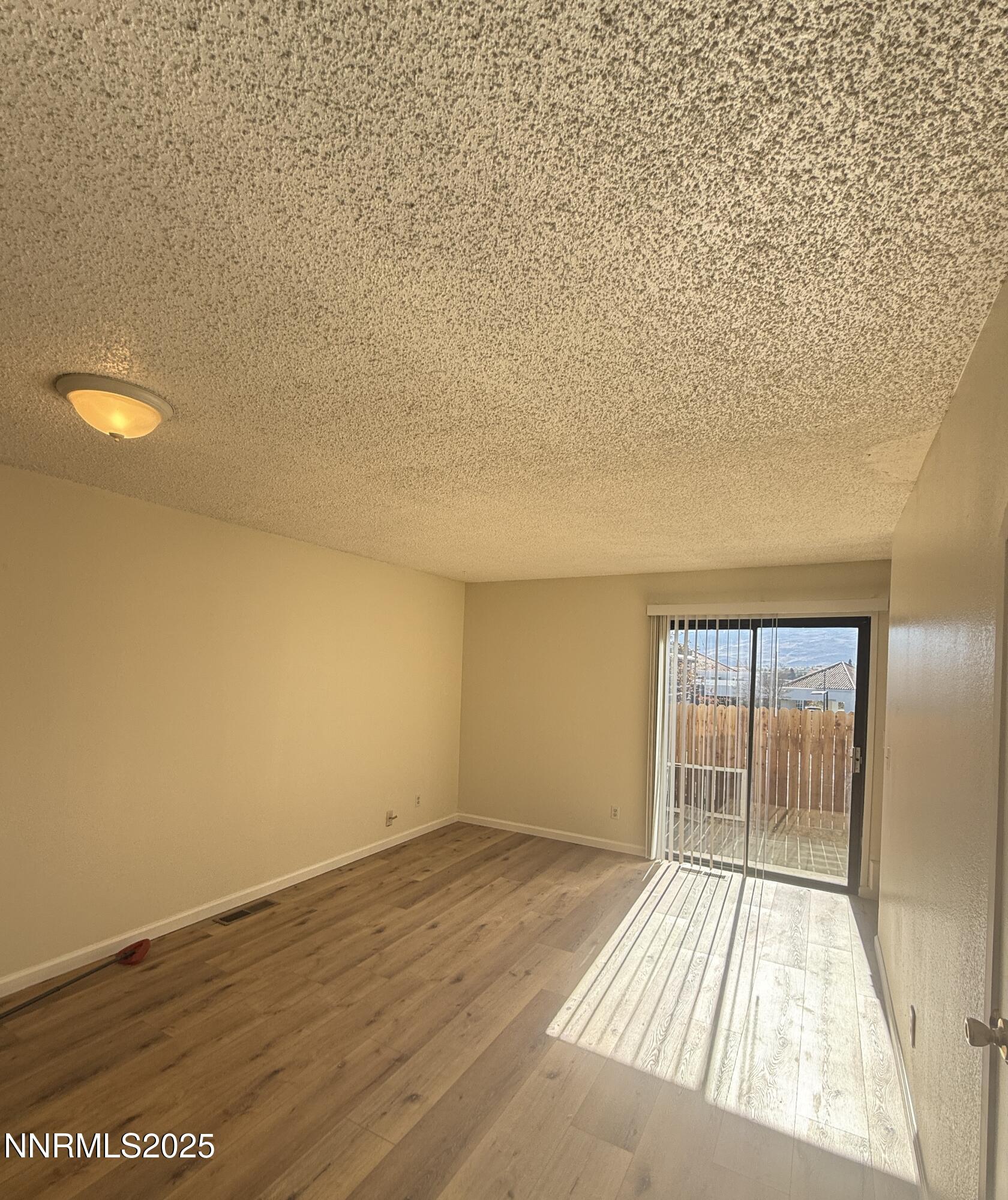 4985 West 7th Street, Unit 16 Reno, NV 89503 - Photo 4 of 10 wooden floor in an empty room with a window