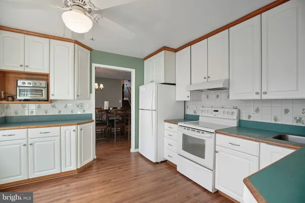 a kitchen with white cabinets and white appliances