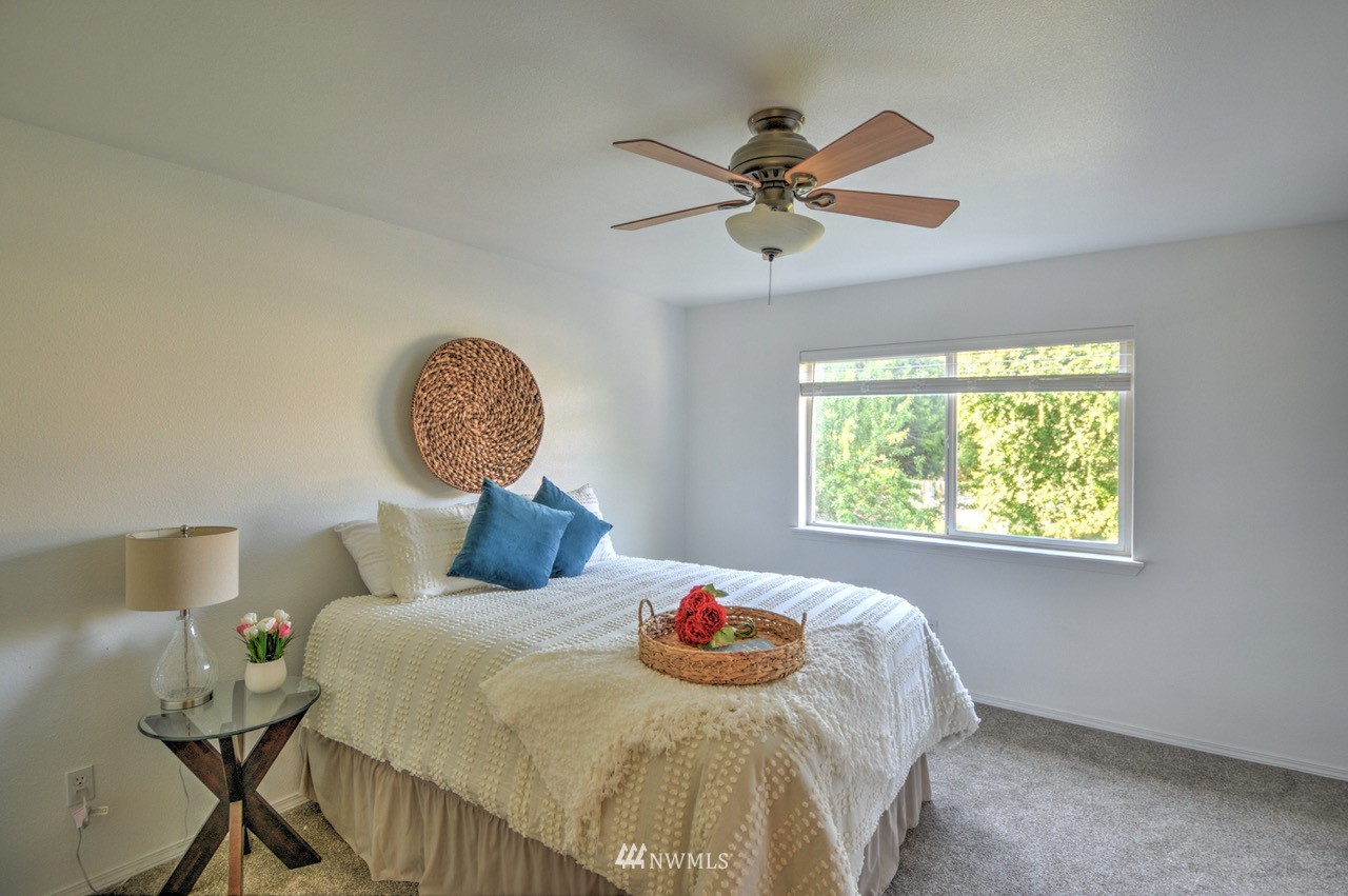 1308 Golf Club Road Southeast Lacey, WA 98503 - Photo 11 of 23 a bedroom with a bed and a chandelier