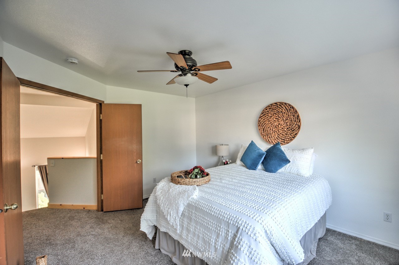 1308 Golf Club Road Southeast Lacey, WA 98503 - Photo 12 of 23 a bedroom with a bed and a chandelier