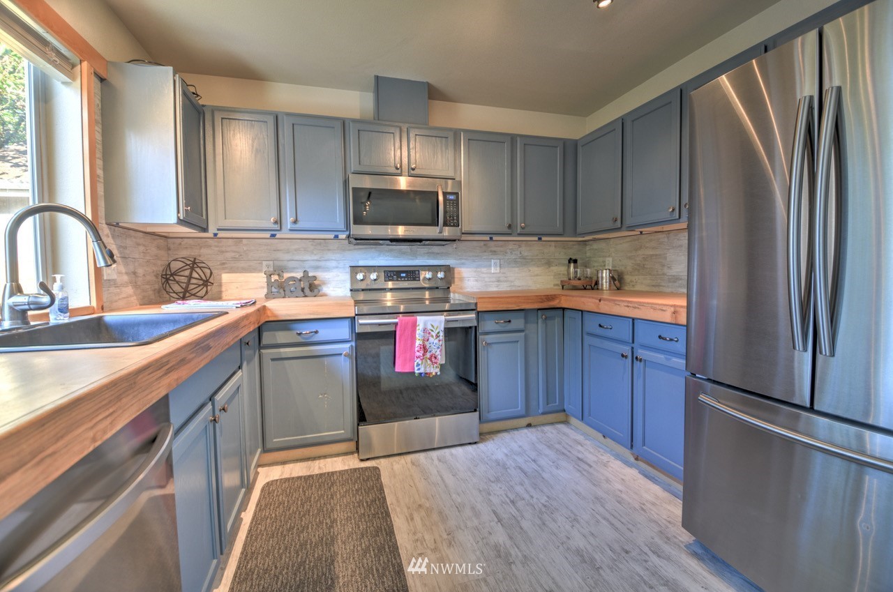 1308 Golf Club Road Southeast Lacey, WA 98503 - Photo 7 of 23 a kitchen with stainless steel appliances granite countertop a refrigerator sink and microwave