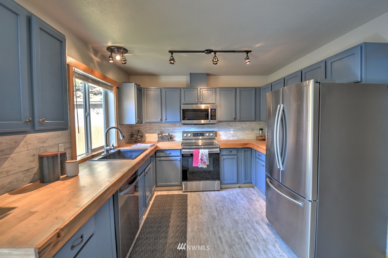 1308 Golf Club Road Southeast Lacey, WA 98503 - Photo 8 of 23 a kitchen with granite countertop a refrigerator stove top oven and sink