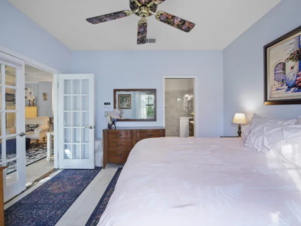 a bedroom with a large bed a chandelier and closet
