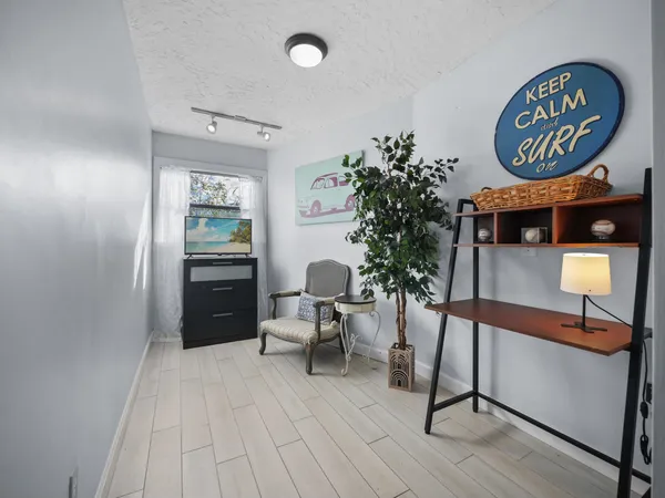 a view of a hallway with wooden floor and a potted plant