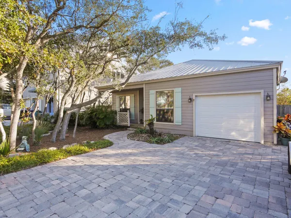 a view of a house with a backyard and a tree