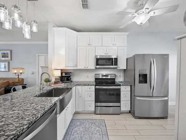 a kitchen with stainless steel appliances granite countertop a sink dishwasher stove and refrigerator