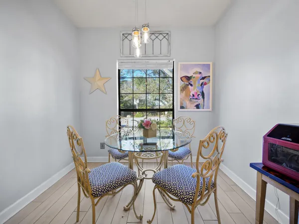 a view of a dining room with furniture a chandelier and wooden floor