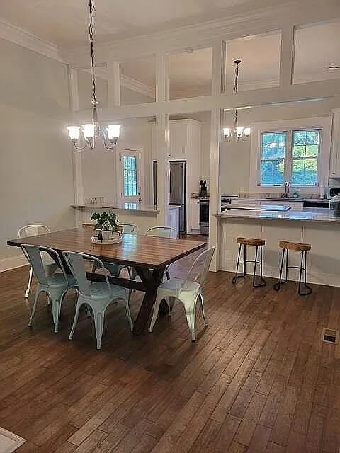 151 South Jackson Street Hartwell, GA 30643 - Photo 7 of 17 a dining room with wooden floor a chandelier a wooden table and chairs