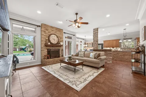 a living room with furniture a fireplace and a floor to ceiling window