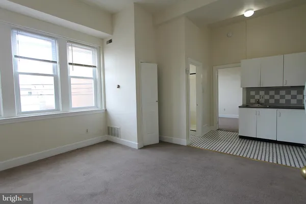 an empty room with a kitchen and a window