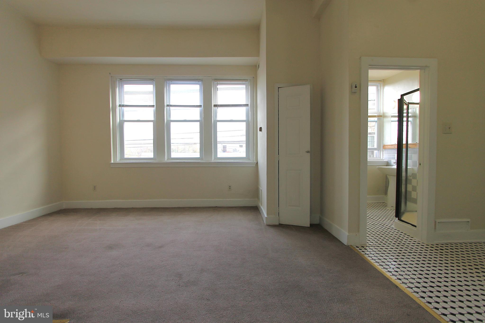 100 East Price Street, Unit 1G Philadelphia, PA 19144 - Photo 4 of 16 an empty room with a window