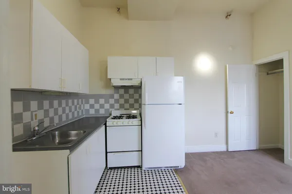 a kitchen with a refrigerator and a stove top oven