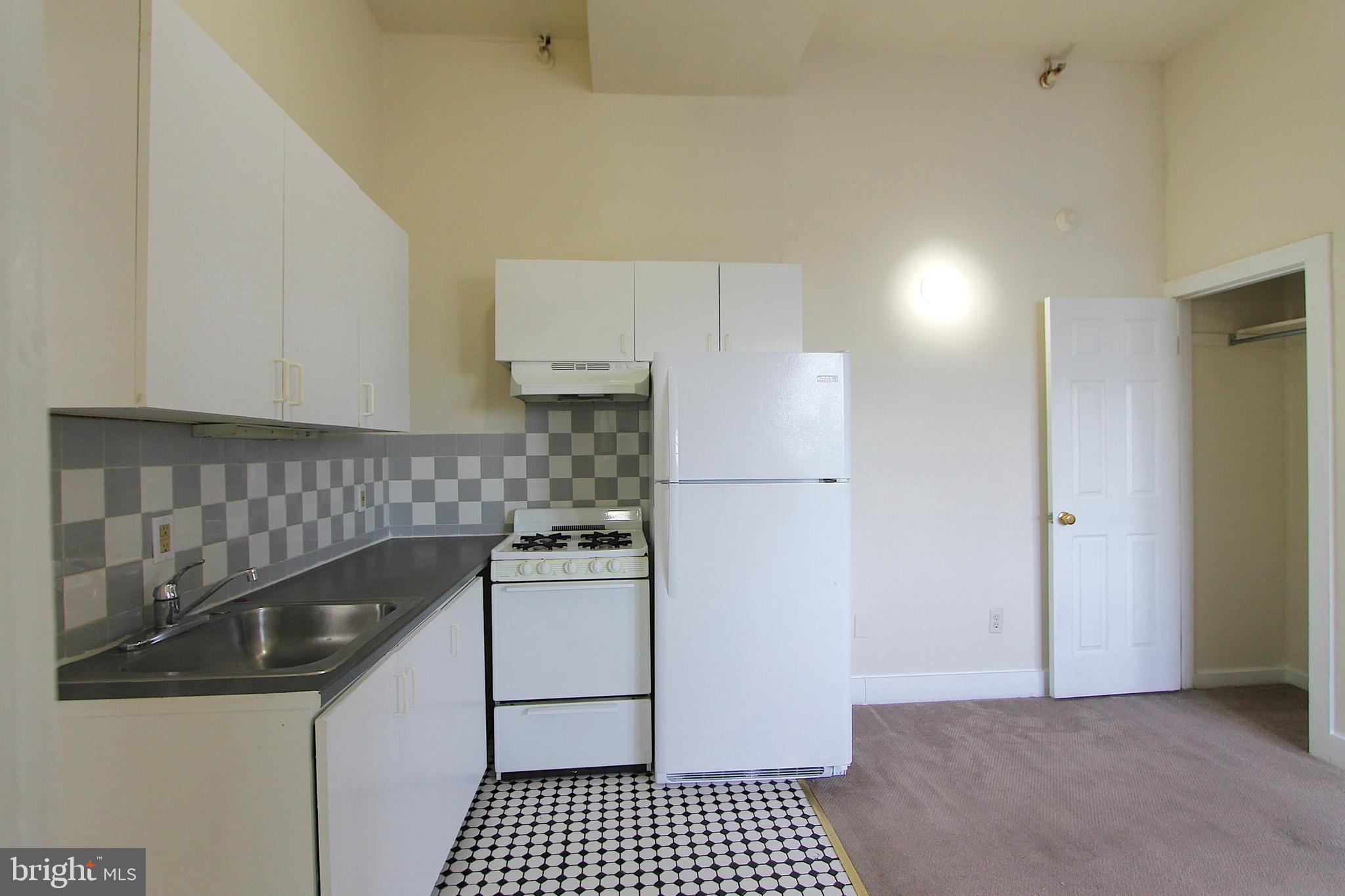 100 East Price Street, Unit 1G Philadelphia, PA 19144 - Photo 8 of 16 a kitchen with a refrigerator and a stove top oven