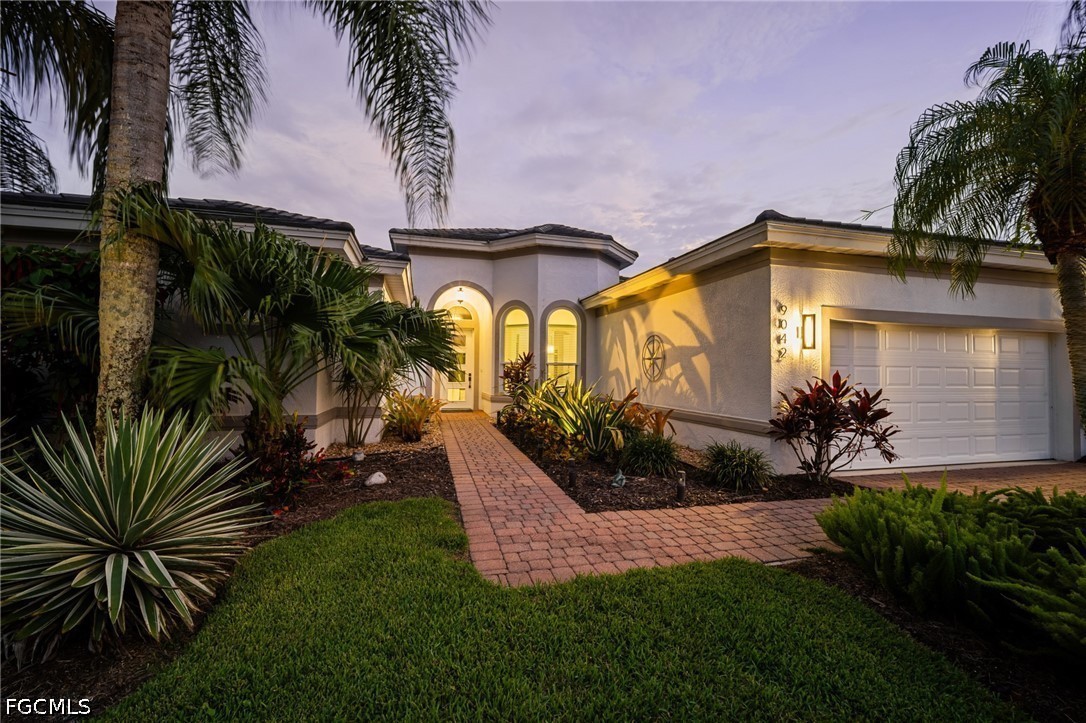 9042 Bronco Court Naples, FL 34113 - Photo 35 of 50 a front view of yellow house with a yard