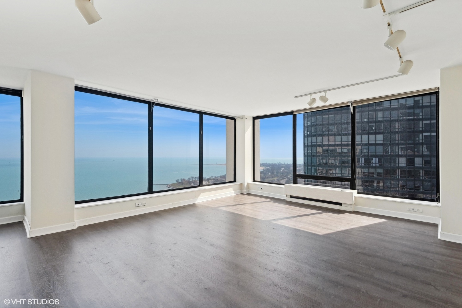 5445 North Sheridan Road, Unit 3812 Chicago, IL 60640 - Photo 2 of 21 a view of an empty room with wooden floor and a window