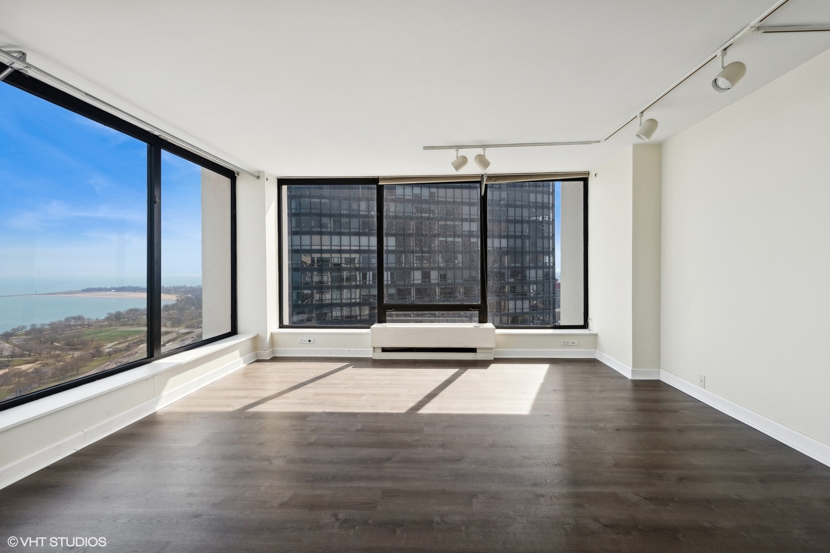 5445 North Sheridan Road, Unit 3812 Chicago, IL 60640 - Photo 3 of 21 a view of an empty room with wooden floor and a window