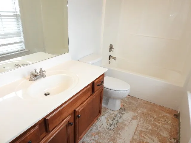 a bathroom with a sink a toilet and a large mirror