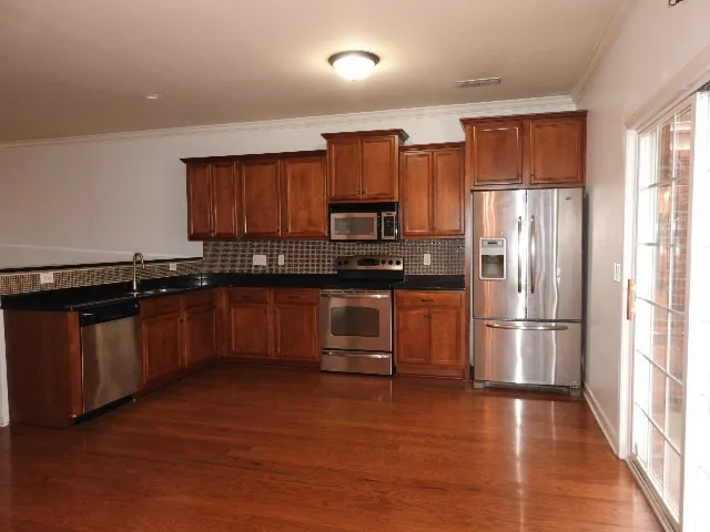 a kitchen with granite countertop stainless steel appliances and wooden cabinets