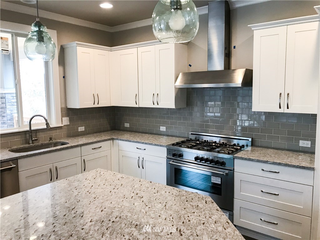 1670 Spaulding Circle Buckley, WA 98321 - Photo 4 of 22 a kitchen with stainless steel appliances granite countertop a sink stove and cabinets