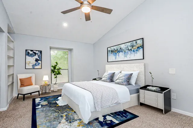 a bedroom with a large bed and a chandelier