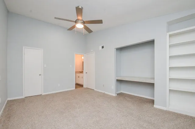 a view of an empty room with a ceiling fan