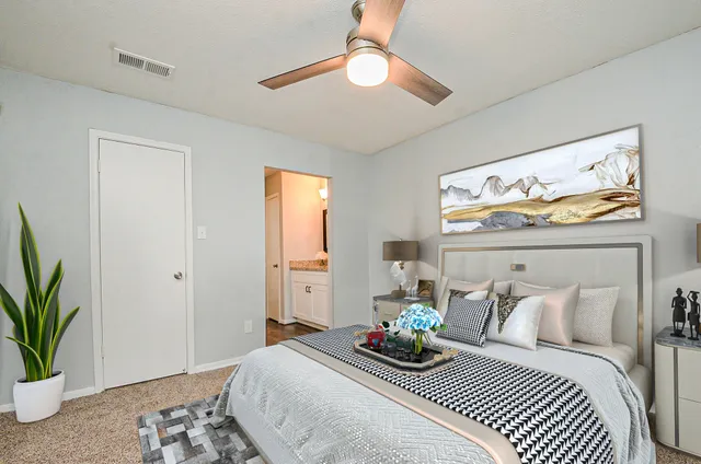 a bedroom with bed and a potted plant