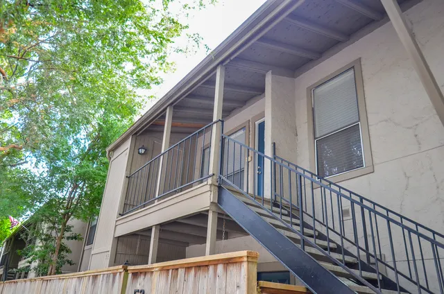 a view of a house with wooden stairs and a table