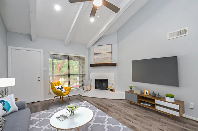 a view of an empty room with a fireplace and fan