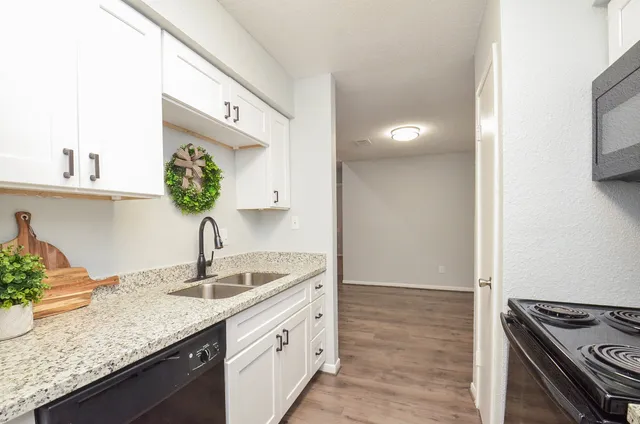 a kitchen with granite countertop a sink stainless steel appliances and cabinets