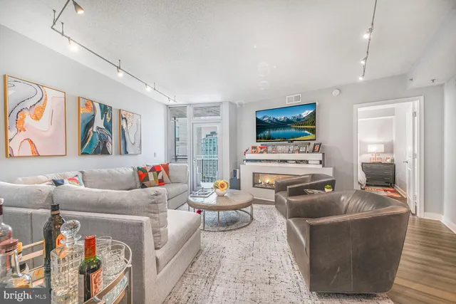 a living room with furniture a flat screen tv and a fireplace