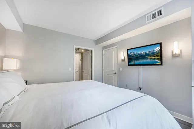 a bedroom with a large bed and a painting on the wall