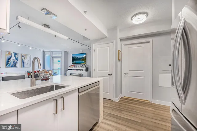a room with stainless steel appliances lots of counter space and wooden floor