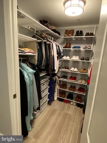 a view of walk in closet with clothes and shoes